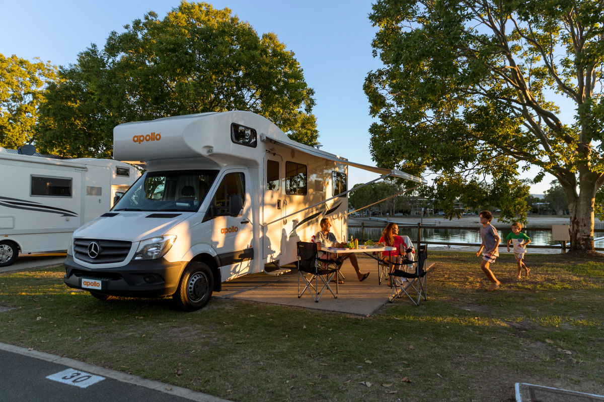 Family with parked Euro Deluxe motorhome at campground